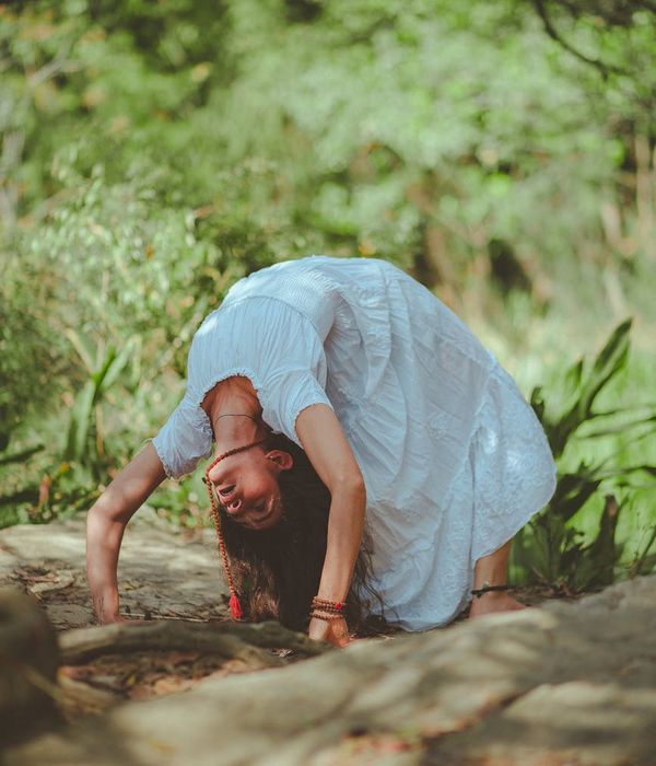 Woman practicing a calm yoga pose in a dark, serene environment.